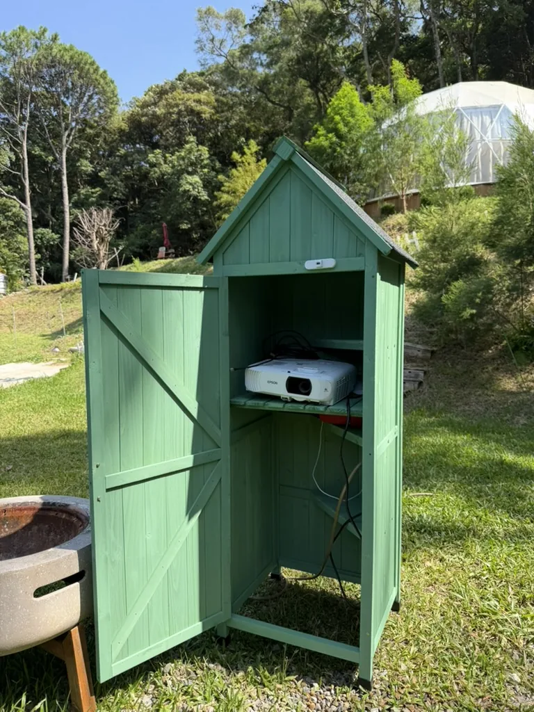 熱氣球房專屬草地白天的綠色戶外投影設備箱，箱內放置 Epson 投影機