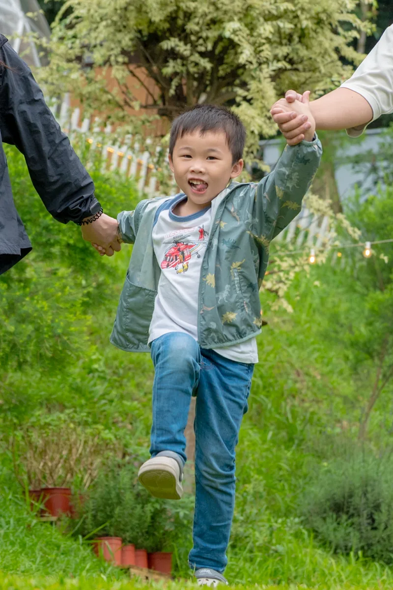 男孩在森林營區的草地上自在奔跑