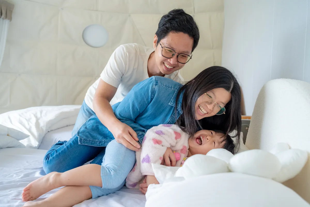 爸爸媽媽與女兒在雲朵房床上溫暖相擁