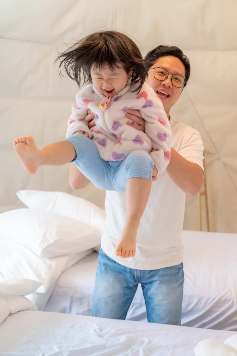 爸爸在帳篷裡把孩子抱高玩耍