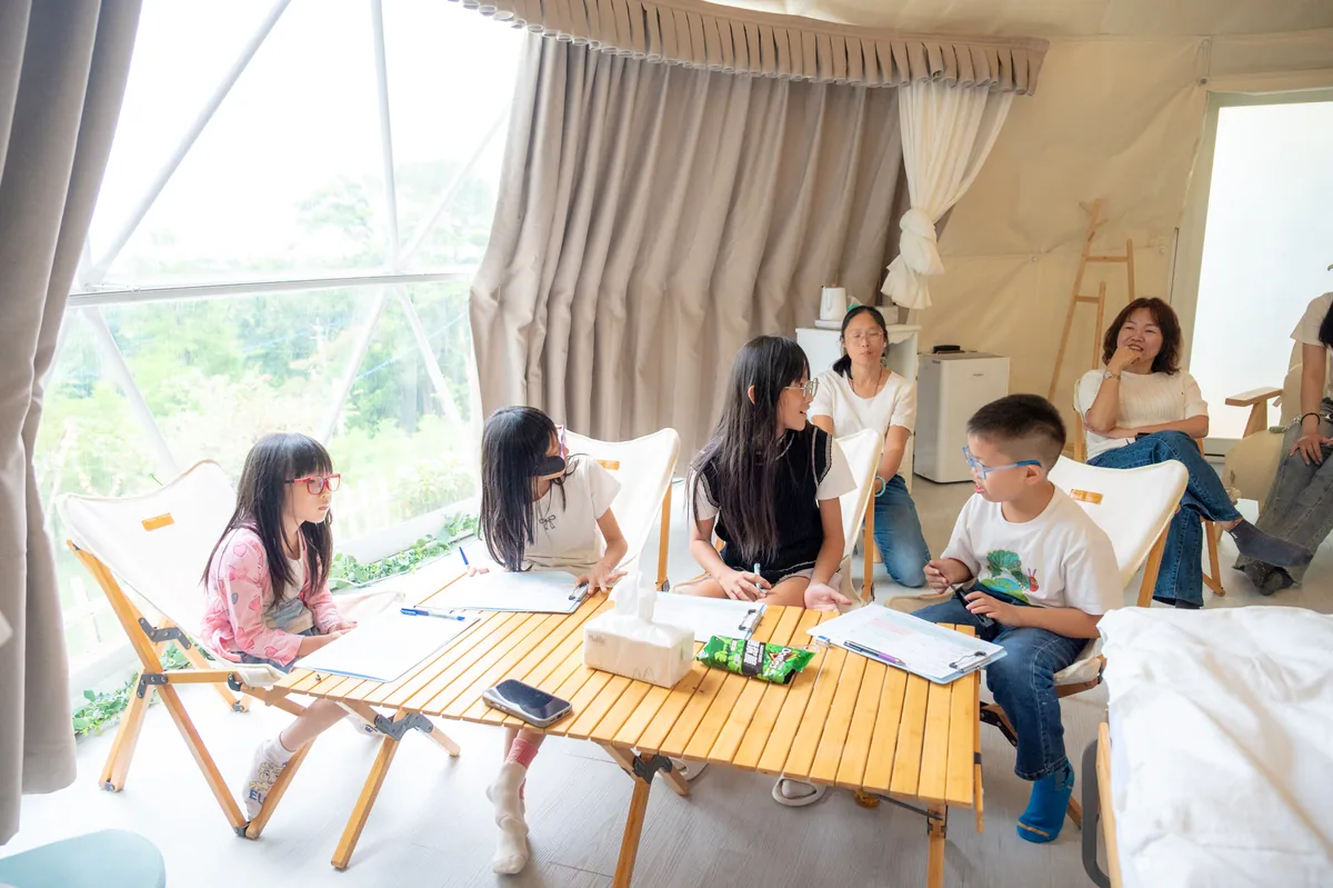 昕閱森林英語的孩子與老師在圓頂帳篷內進行攝影課